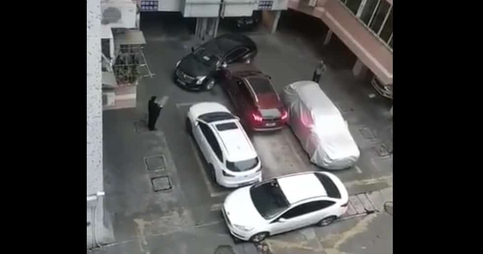 Zdenerowawny kierowca przepycha auto na parkingu
